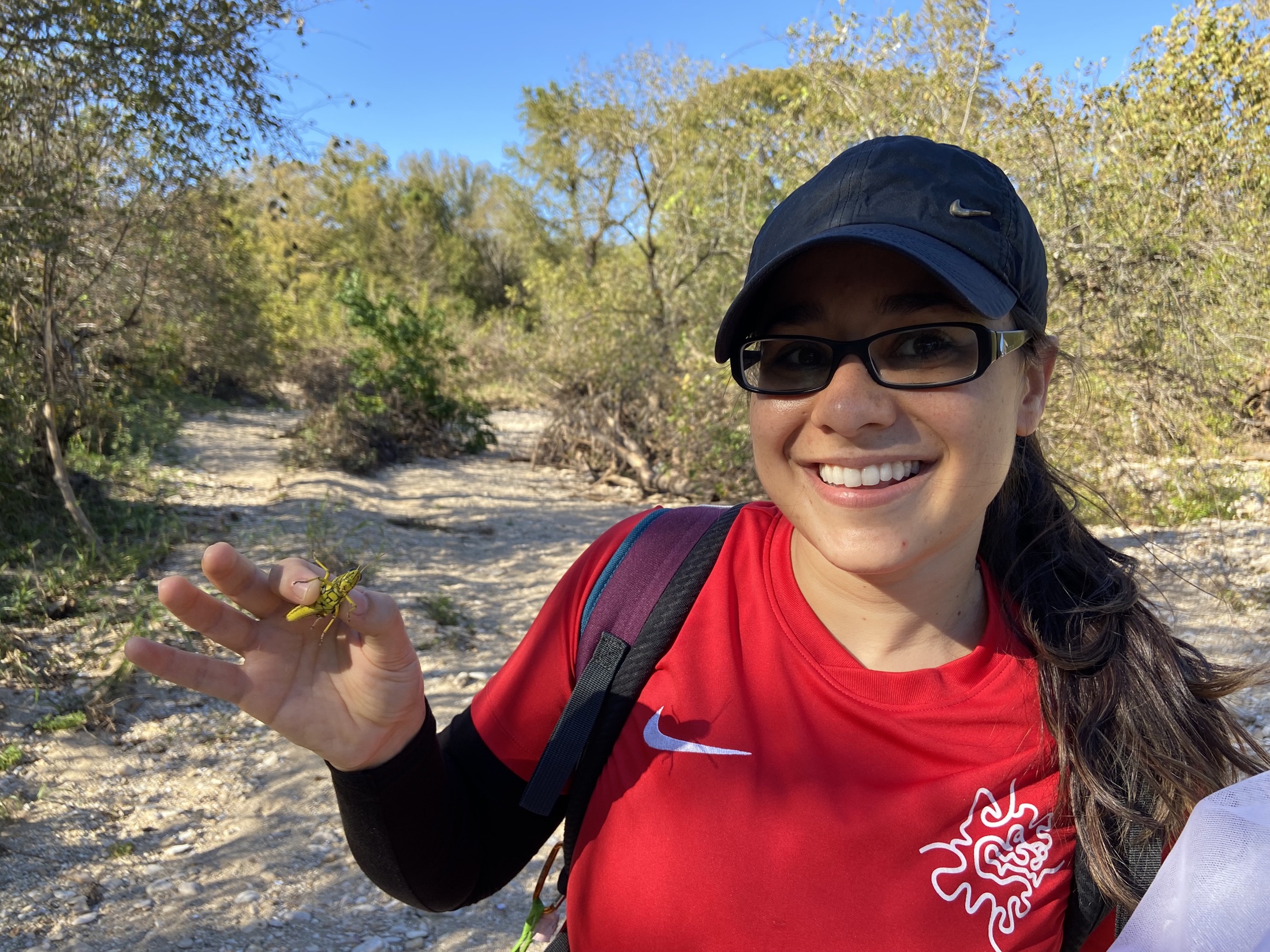 Maéva Techer holding a locust during fieldwork.